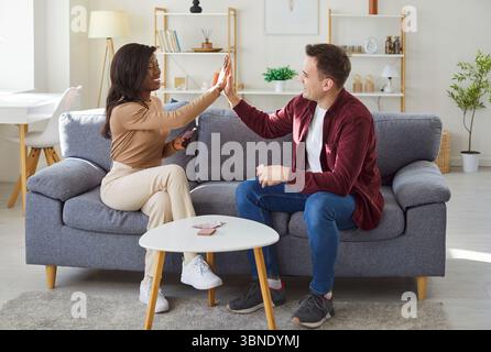 Multirassisches junges Paar, junge interrassische Familie zu Hause, die Kartenspiel spielt Stockfoto