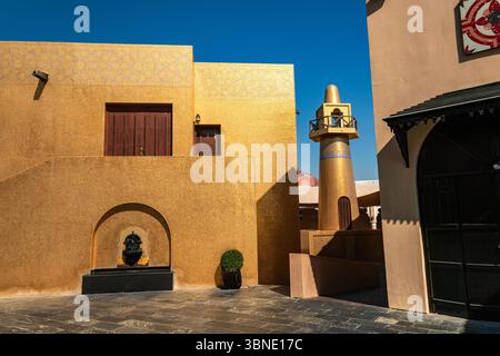 Doha, Katar. Im Katara Cultural Village steht ein goldenes Minarett, das die komplexe Architektur und das kulturelle Erbe der Re zeigt Stockfoto