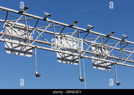 Verkehrslinie über der Autobahn mit mehreren Sensoren für Geschwindigkeitskontrolle und Nummernschildregistrierung als Symbol für moderne Infrastruktur und Überwachung Stockfoto