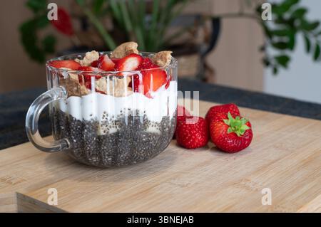 Genießen Sie ein lebhaftes Chia-Parfait mit Joghurt, Erdbeeren und Granolaa, das perfekte Frühstück oder Snack ist Stockfoto