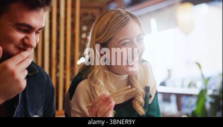 Leute, essen und lachen mit Essen im Restaurant zum Mittagessen, zum Zusammenknüpfen und zum Geburtstag. Glücklich, Freunde und lustiger Witz mit Sushi, einheimische asiaten Stockfoto