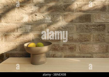 Elegantes mediterranes Stillleben im Sommer. Frische Zitronenfrüchte in moderner beiger Schüssel auf Holztisch. Natürliches Sonnenlicht. Strukturierte Ziegelwand Stockfoto