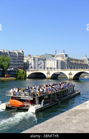 Touristen, die eine Bootsfahrt entlang der seine in Paris genießen. Sommerblick von der Bootstour an einem sonnigen Tag Stockfoto