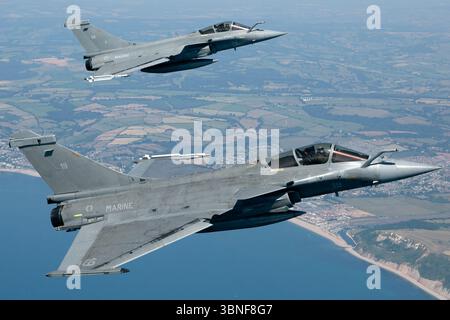 Ein Paar einsitziger Dassault Rafale M-Marinekämpfer, die die Registrationen 19 und 34 von Flottille 11F/12F tragen, überqueren RNAS Yeovilton. Diese trägerfähigen Multifunktionsjets verfügen über Dreiecksflügel und zwei SNECMA M88-Turboventilatoren. Stockfoto
