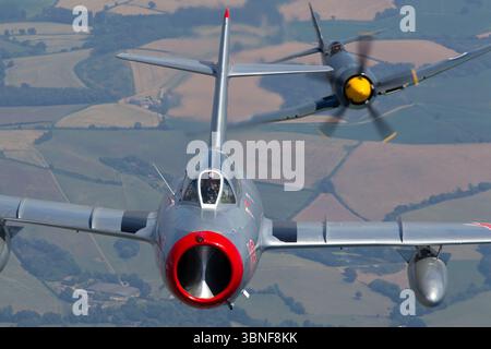 Ein Formationsflug über Yeovilton zeigt die Hawker Sea Fury T20S der Royal Navy Historic Flight, Kennzeichen VX281, gepaart mit einem sowjetischen PZL-Mielec Lim-2 (MiG-15), Kennzeichen N104CJ. Beide Flugzeuge sind in der Geschichte der militärischen Luftfahrt von Bedeutung und stellen Technologien aus der Zeit nach dem Zweiten Weltkrieg und des Kalten Krieges dar. Stockfoto