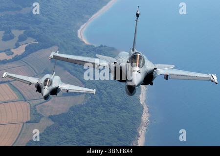Zwei französische Rafale M-Jagdflugzeuge mit den Hecknummern 19 und 34 fliegen über Yeovilton. Diese Trägerkompatiblen Multifunktionsjets verfügen über Delta-Flügel, zwei Safran M88‑2-Turbolüfter, RBE2‑AESA-Radar, IRST und Luftbetankungsfähigkeit. Stockfoto