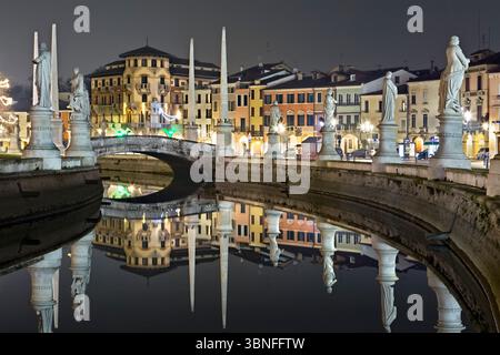 Brücke und Skulpturen des Prato della Valle mit dem Sacerdoti-Palast, der sich im Kanal spiegelt. Padua, Venetien, Italien. Stockfoto