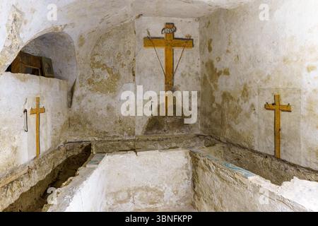 Ein feierlicher Blick auf eine alte unterirdische Krypta in der Kirche der Gesu (Casa Professa) in Palermo, Sizilien, mit einem rustikalen Steinaltar und einem W Stockfoto