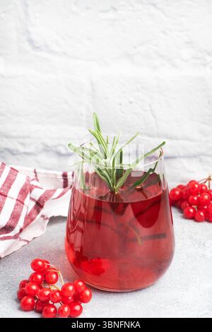 Trinken Sie aus den Beeren des roten Viburnums in Glas Becher. Beerenkompott mit Vitamin C gegen den üblichen kalten Kopierraum. Stockfoto
