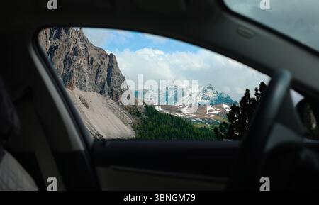 Blick vom Autofenster auf Berge und Landschaft Dolomiten Alpen, schneebedeckte Berggipfel, Autofahrt Stockfoto