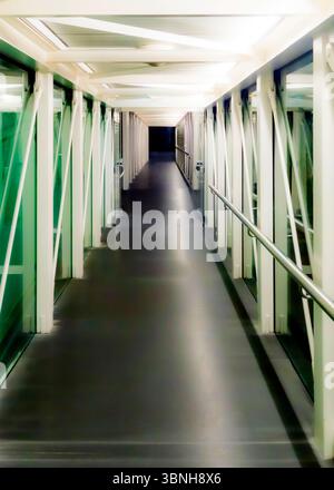 Ein leerer Flur mit Glaswänden und dunklem Boden. Stockfoto
