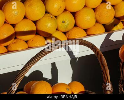 Sonnendurchflutete Orangenfrucht im Korb beim Anbieter für Außenmärkte Stockfoto