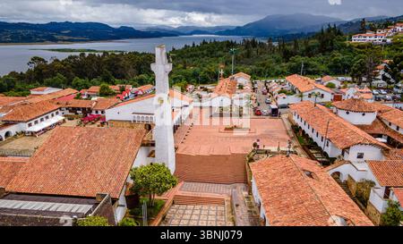 Panoramablick auf Guatavita mit seiner bezaubernden Architektur und der atemberaubenden Laguna de Guatavita im Hintergrund. Stockfoto