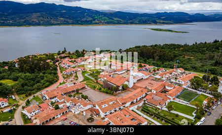 Atemberaubende Aussicht auf Guatavita aus der Vogelperspektive mit Blick auf die pulsierende Stadt und Laguna de Guatavita vor einem Hintergrund üppiger Landschaften. Stockfoto