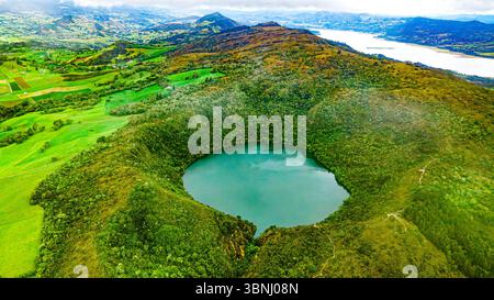 Atemberaubender Blick aus der Vogelperspektive auf die Laguna de Guatavita, umgeben von üppiger grüner Landschaft in Cundinamarca, Kolumbien, und zeigt die Schönheit der Muisca-Kultur. Stockfoto