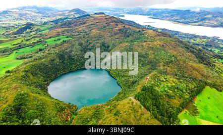 Atemberaubende Aussicht auf die Laguna de Guatavita, umgeben von üppigem Grün und Bergen in Cundinamarca, Kolumbien. Stockfoto