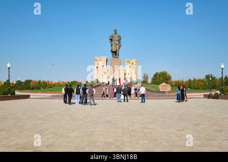 Eine typische Szene einer Hochzeitsfeier, die Fotos macht. An der riesigen Skulptur Amir Timur, Statue des Führers in Shahrisabz, Usbekistan. Stockfoto