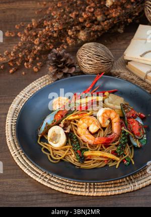 Spaghetti mit scharfen Meeresfrüchten, ein Gericht mit frischem Pfeffer, Gewürzen und Chili. Es hat einen scharfen Geschmack. Gib Garnelen und Tintenfische hinzu. Stockfoto