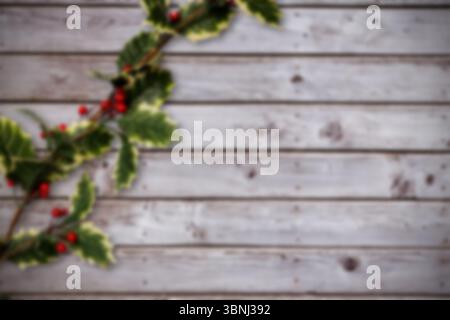 Das flache Design im Urlaubsstil zeigt einen gelbumrandeten stechpalmenzweig mit roten Beeren auf Holzhintergrund Stockfoto