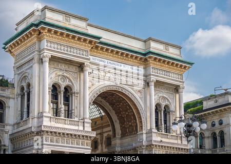 Mailand, Italien. Juni 2025. Der monumentale Eingangsbogen der Galleria Vittorio Emanuele II mit kunstvoller neoklassizistischer Dekoration unter sonnigem Himmel Stockfoto