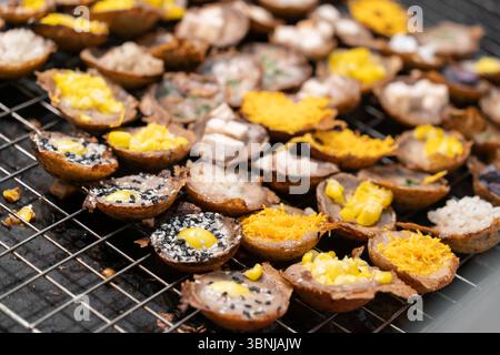 Khanom Krok ist ein beliebtes thailändisches Streetfood-Dessert. Es sind kleine runde Kokosnussmilchpfannkuchen. Stockfoto