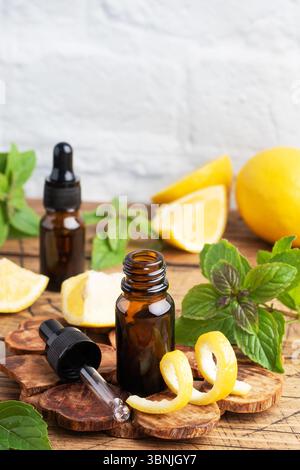Zitrusfrucht ätherisches Öl und Minze, Aromatherapie-Öl natürliche organische Kosmetik auf rustikalem Holzhintergrund Stockfoto