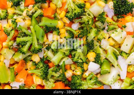 Eine lebendige Nahaufnahme farbenfroher Gemüsemischung mit Brokkoli, die frische Texturen und Farben zeigt. Ideal für Hintergründe, die gesundes Essen hervorheben Stockfoto