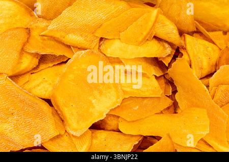 Eine Nahaufnahme mit getrockneten Bananenscheiben, die ihre einzigartige Textur zeigen. Ideal als natürliches und lebendiges Hintergrundbild für Präsentationen gesunder Lebensmittel Stockfoto