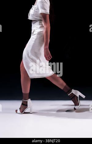 Frau mit Tweed-Jacke und -Rock, klassische Mode-Kleidung auf schwarzem Hintergrund Stockfoto