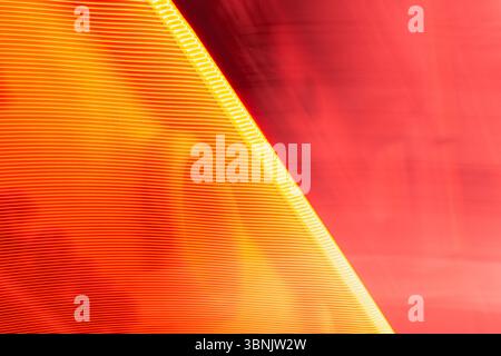 Abstrakter heller Hintergrund mit dynamischen Rot- und Orangetönen mit hellen Linien. Perfekt für kreative Designs, technische Themen und moderne Künstler Stockfoto
