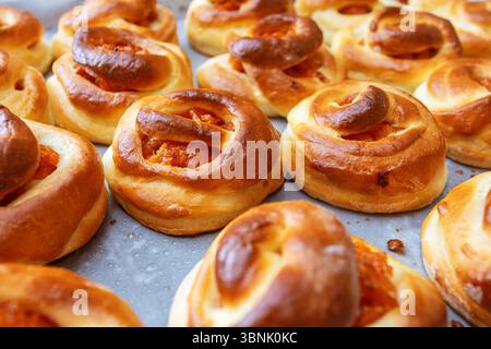 Frisch gebackene, hausgemachte Brötchen gefüllt mit Aprikosenmarmelade und Hüttenkäse, die das Wesen des gemütlichen Backens in der Küche einfangen. Perfekt als rustikales Dessert oder a s Stockfoto