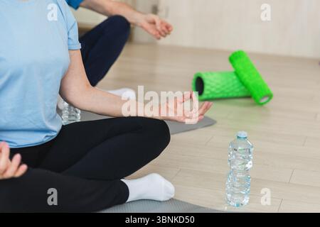 Yoga-Achtsamkeitsmeditation. Älteres Ehepaar, das zu Hause Yoga praktiziert. Hände in Kinnmudra-Geste. Alte Ehefrau sitzt in Lotusposition und Meditation entspannend. Familie, die Atemübungen macht. Stockfoto