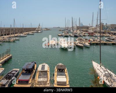 Ein großer Blick auf den Yachthafen im Hafen von Barcelona, gefüllt mit Segelbooten und Motoryachten, die an einem klaren Sommertag an den Docks ankern. Spanien Stockfoto