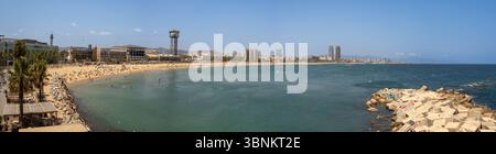 Panoramablick auf die Küste Barcelonas vom Strand Sant Sebastià, mit dem Port Cable Car Tower und den zwei Wolkenkratzern von Port Olímpic in der Ferne. Stockfoto