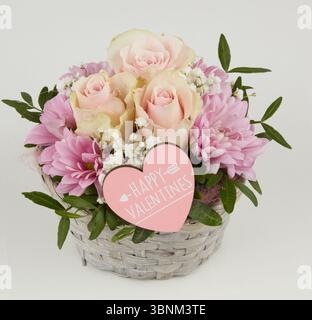 Blassgelbe Rosen blühen am Valentinstag in einem gewebten Holzkorb. Stockfoto
