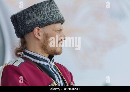 August 2024. Weißrussland, Bezirk Petrikow. Lyaskovichi Dorf. Festival der ethnischen slawischen Kulturen. Ein kubanischer Kosakenmann in einem ethnischen astrachan Hut in Stockfoto