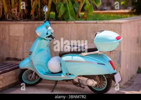 Ein blauer Roller steht in der Nähe der Stadtmauer. Stockfoto