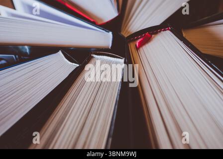 Stapel offener Bücher auf dem Holztisch. Großansicht der Seiten. Abstraktes Konzept von Wissen, Bildung, Lernen und Literatur. Stockfoto
