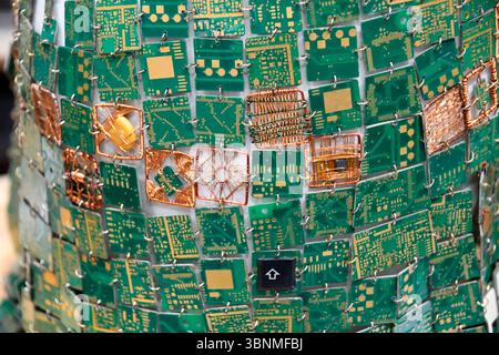 Mosaik aus bestückten Teilen von Computerplatinen mit verschiedenen elektronischen Komponenten Stockfoto