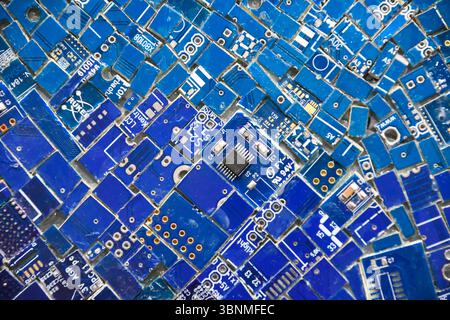 Mosaik aus bestückten Teilen von Computerplatinen mit verschiedenen elektronischen Komponenten Stockfoto