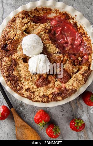 Glutenfreier Kakaoerdbeerenschuss mit Vanilleeis in der Backform auf dem Tisch. Vertikale Draufsicht von oben Stockfoto