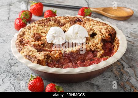 Hausgemachter Kakao-Erdbeere-Cobbler mit Vanilleeis in Backform auf dem Tisch. Horizontal Stockfoto