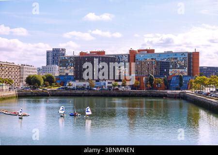 Bassin du Commerce mit Segelschullehrbooten und Blick auf den Quai d'Angouleme (Angouleme) mit Hotel Mercure Le Havre Centre und NRJ-Radiosendergebäude in Le Havre an der Alabasterküste (Cote d'Albatre) im Departement seine-Maritime in der französischen Normandie Stockfoto