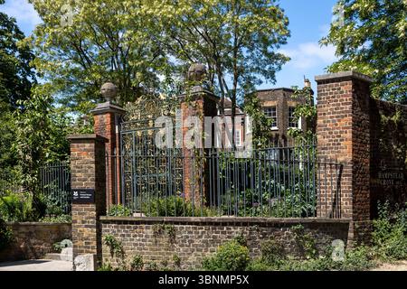 London, UK, 7. Mai 2025, Eingangstor zum Fenton House and Garden in Hampstead, London, mit Schmiedeeisen und Ziegelwerk unter Sommerbäumen Stockfoto