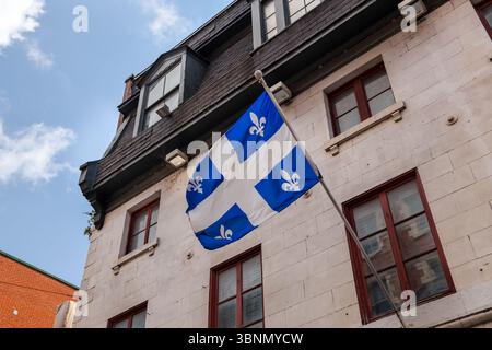 Die Québec-Flagge, die von einem Gebäude in Old Montreal aus fliegt Stockfoto