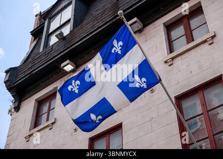 Die Québec-Flagge, die von einem Gebäude in Old Montreal aus fliegt Stockfoto