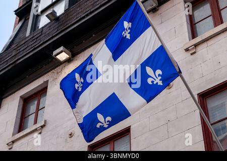 Die Québec-Flagge, die von einem Gebäude in Old Montreal aus fliegt Stockfoto
