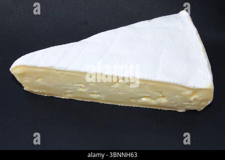 Cheese Brie auf schwarzem Hintergrund. Köstlicher Käse mit weißem Schimmel. Weicher Dijon Brie Ausschnitt. Stockfoto
