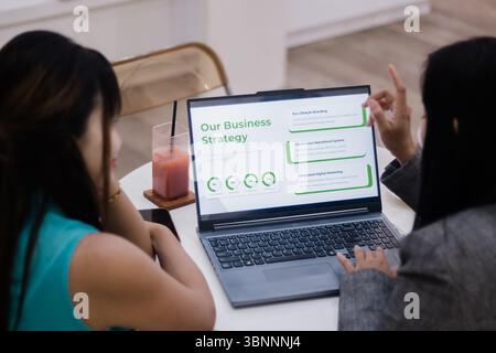 Zwei Geschäftsfrauen, die mit einem Laptop an einer Strategie arbeiten. Gemeinsame Diskussion nachhaltiger Geschäftspraktiken und Marketinglösungen im Büro. Stockfoto