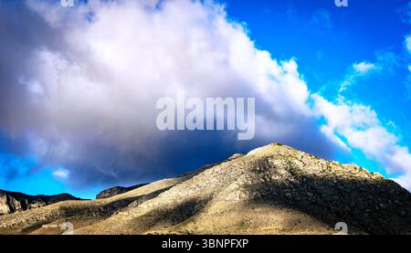 Dramatische Wolken brühen sich über den Guadalupe Mountains, während das Sonnenlicht durchbricht und Licht und Schatten über die zerklüfteten Bergrücken wirft. Stockfoto